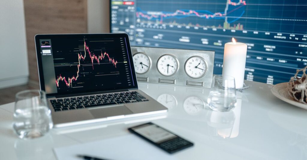 Beginner forex trader studying indicators on a candlestick chart on a laptop screen