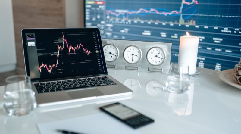 Beginner forex trader studying indicators on a candlestick chart on a laptop screen