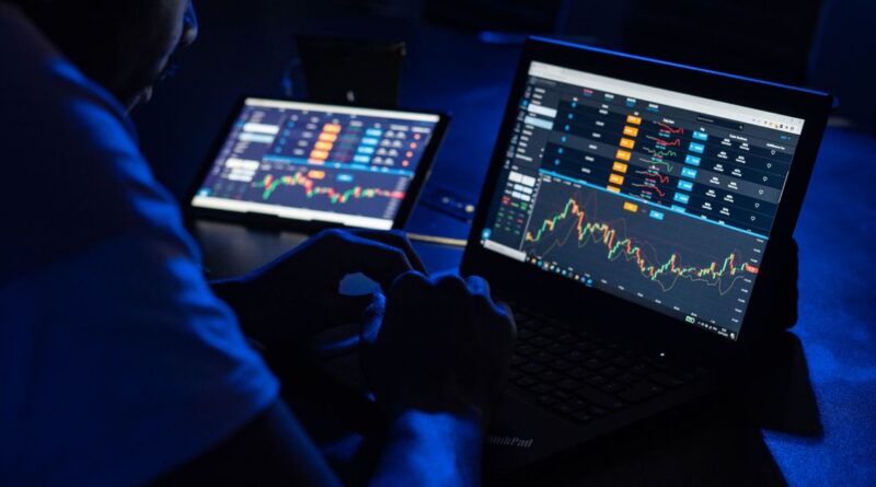 Trader adding technical indicators to an MT5 chart on a laptop