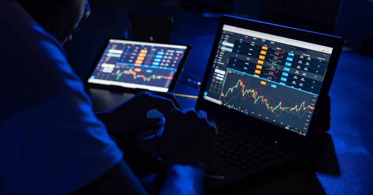 Trader adding technical indicators to an MT5 chart on a laptop