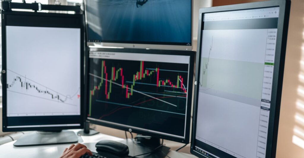 Multi-monitor day trading desk displaying Forex charts and indicators across several timeframes