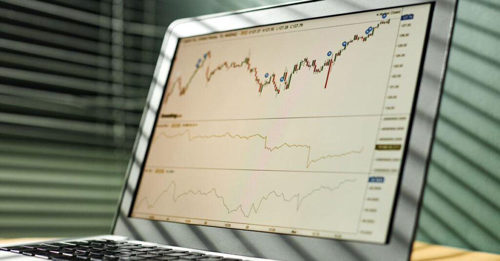 Comparison of MT4 Forex indicators on a candlestick chart laptop showing trend and momentum tools