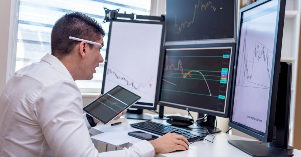 Multi-monitor trading desk used to filter false buy sell signal indicator arrows with confluence