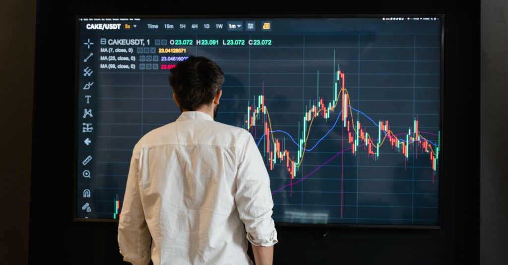 Candlestick chart on a trading monitor illustrating a MACD divergence reversal at a swing low