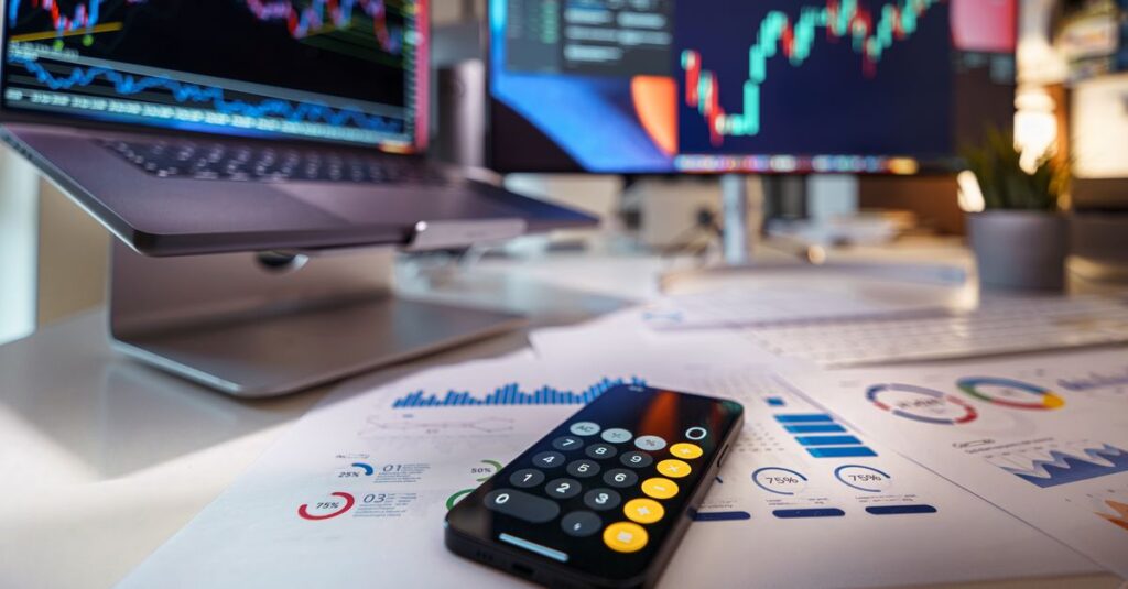 Multi-monitor trading desk with Forex charts used to test MACD divergence settings across timeframes